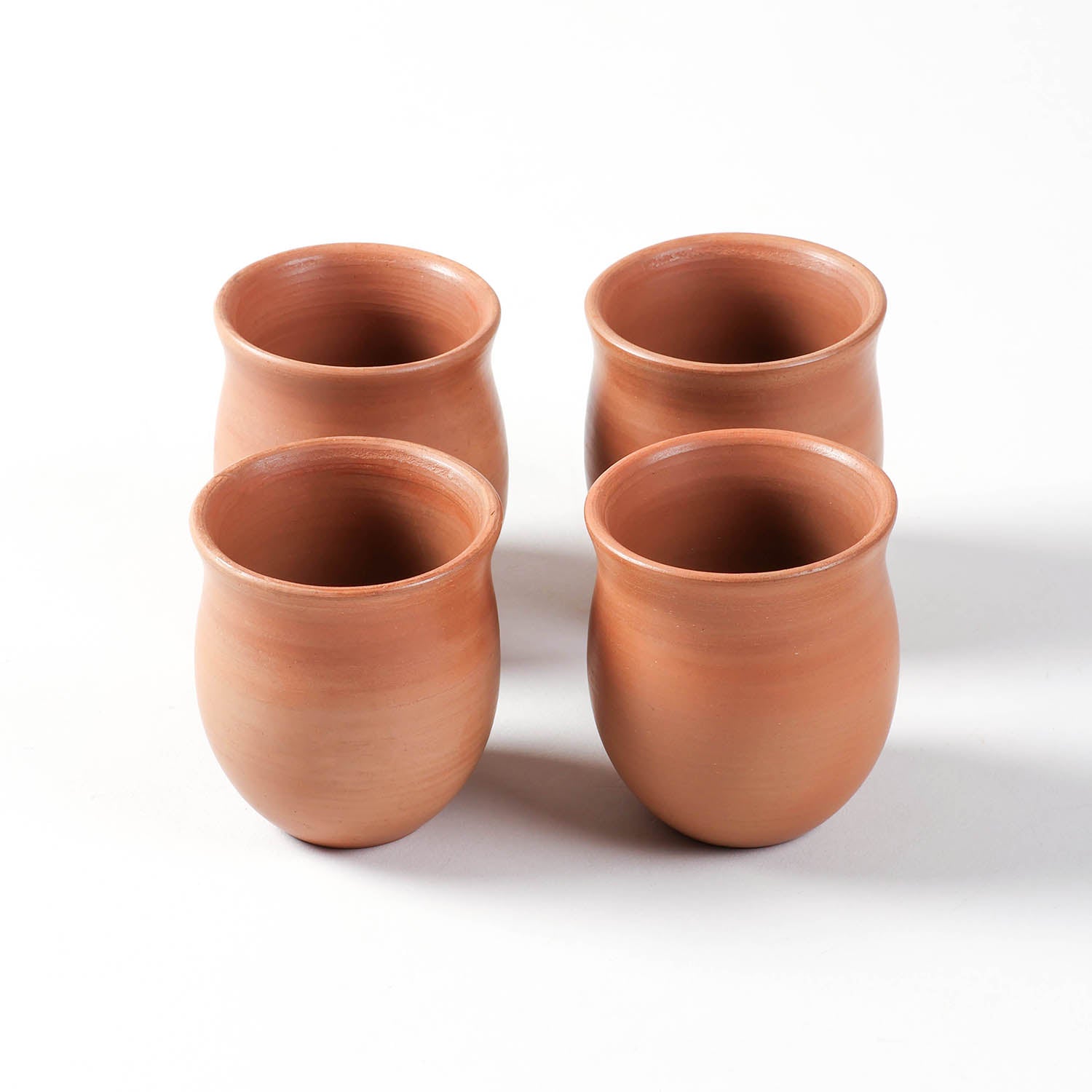 Curved terracotta kulhad cups set of 4, handmade clay tea cups for chai, coffee, and everyday use.