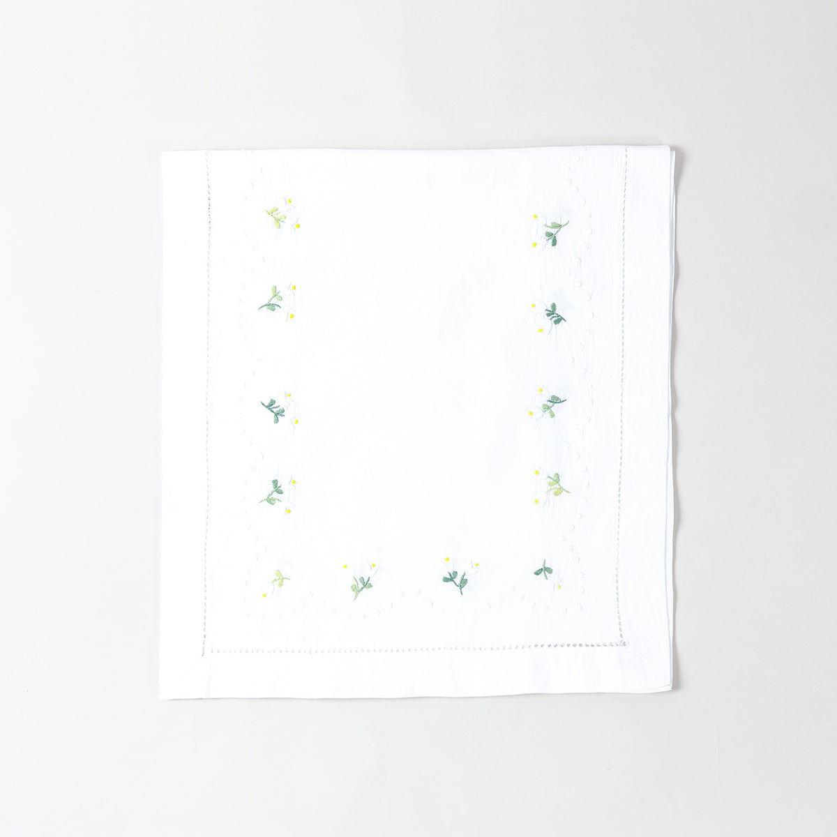 Folded white cotton table runner showcasing delicate daisy embroidery and handcrafted Bengal chikankari detailing