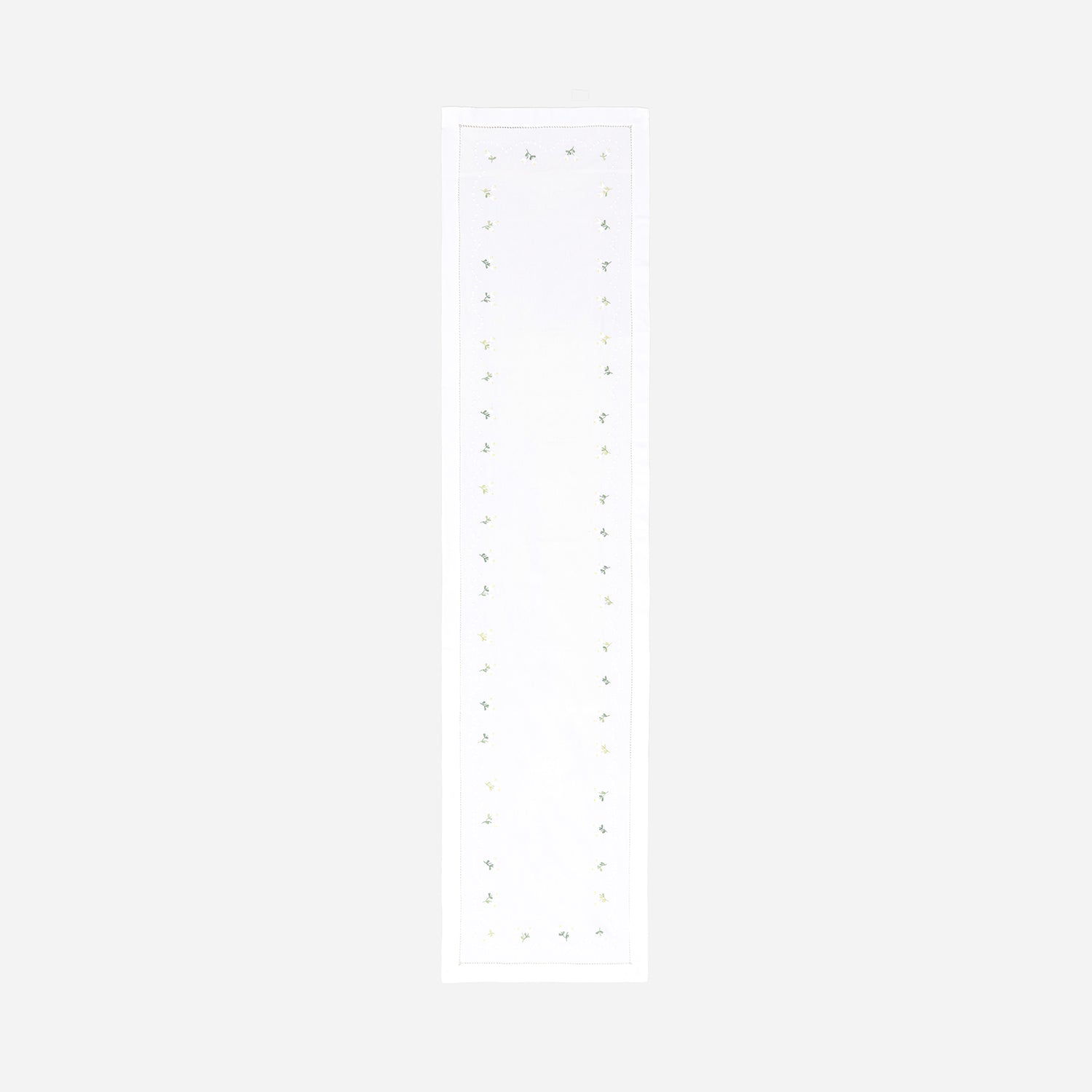 Full-length hand embroidered table runner featuring white, yellow, and green daisy motifs on a white cotton base displayed on a plain background