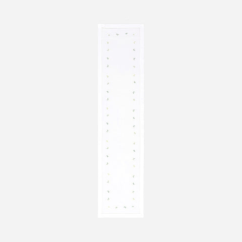Full-length hand embroidered table runner featuring white, yellow, and green daisy motifs on a white cotton base displayed on a plain background
