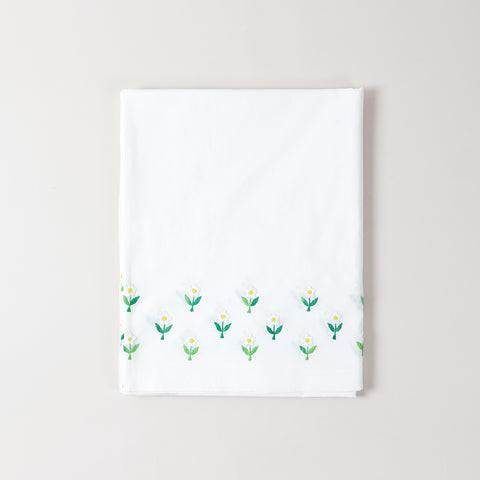 Folded embroidered cotton table cloth showcasing daisy floral motifs and handcrafted cutwork craftsmanship