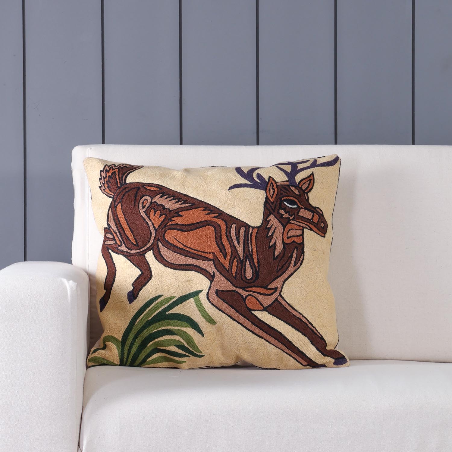 Deer hand embroidered crewel cushion cover styled on a sofa adding warmth and artisanal charm to living room decor