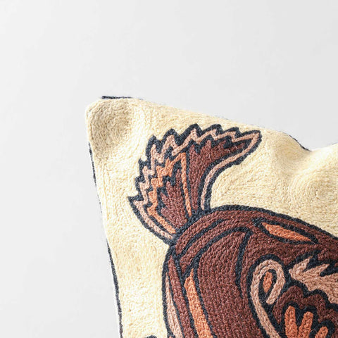Close-up of deer crewel embroidery, highlighting intricate wool stitching and handcrafted detailing on a beige base