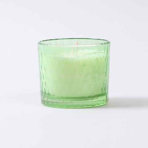 Detailed close-up of green soy wax filled inside a high-quality glass container.