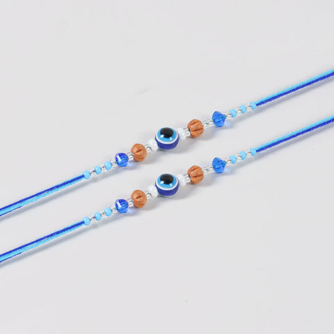 Close-up of the Handmade Evil Eye Rakhi featuring a protective evil eye bead,, decorative beads, and blue cotton thread.