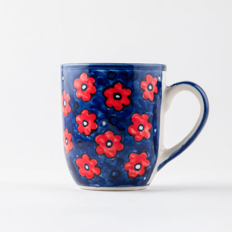 Handpainted ceramic mug with floral motifs in blue and red, ideal for coffee, tea, and everyday tableware use