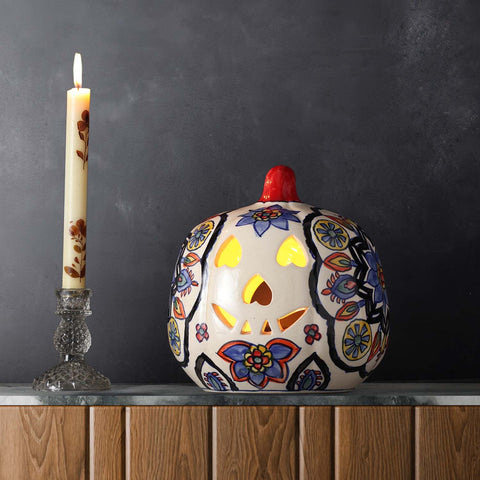 Multi-coloured floral ceramic pumpkin tea light holder styled on a console table creating a festive and decorative home setting