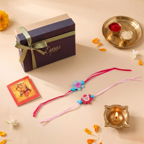 Floral Ribbon Wooden Teddy Bear Kids Rakhi Set of 2 with pink and blue satin ribbon flowers, presented in a gift box, ready for Raksha Bandhan gifting
