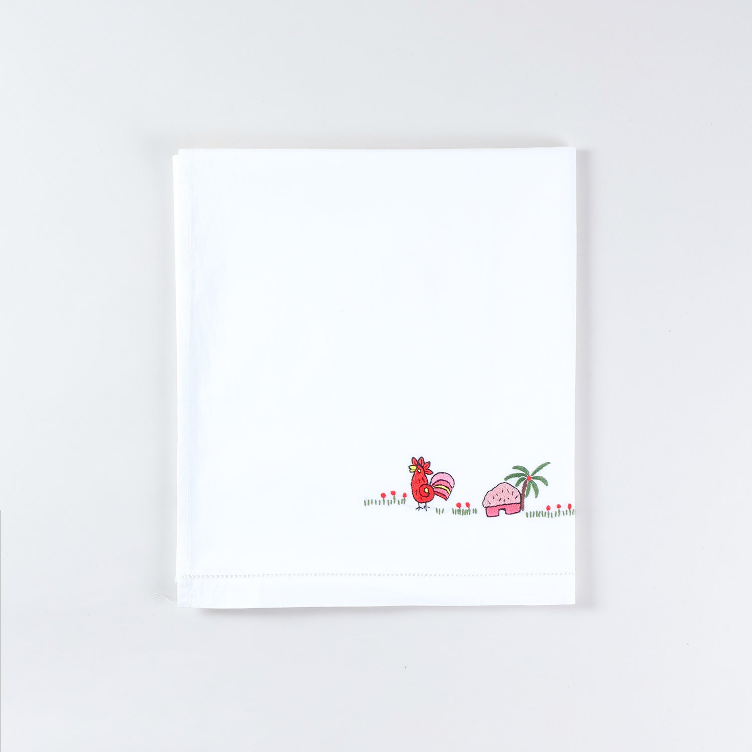 Neatly folded handmade cotton kids bed linen with Bengal Chikankari duck embroidery from the kids collection