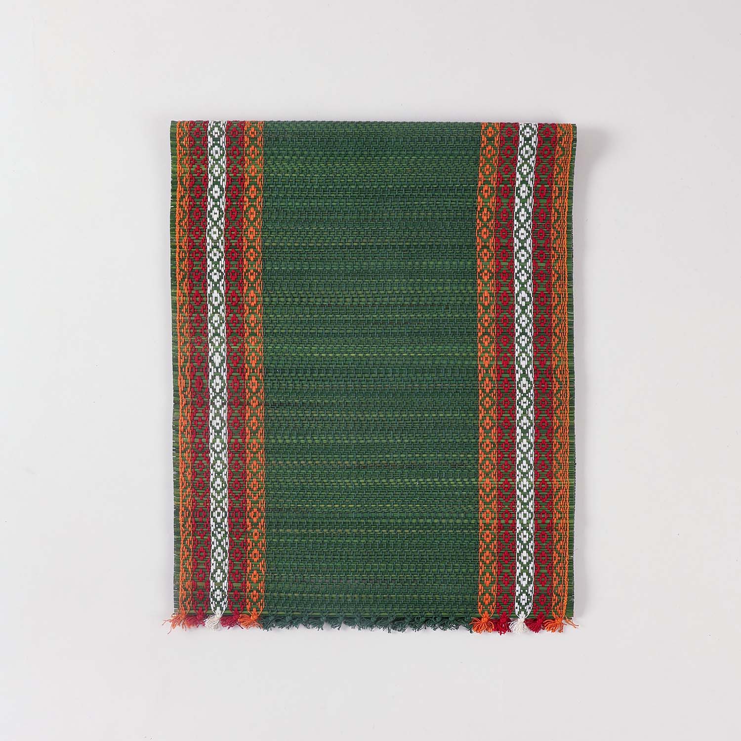 Folded green Madhurkathi table runner crafted from natural river grass with handwoven texture and contrasting border details