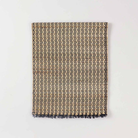 Folded Madurkathi table runner crafted from natural river grass with black detailing and handwoven texture