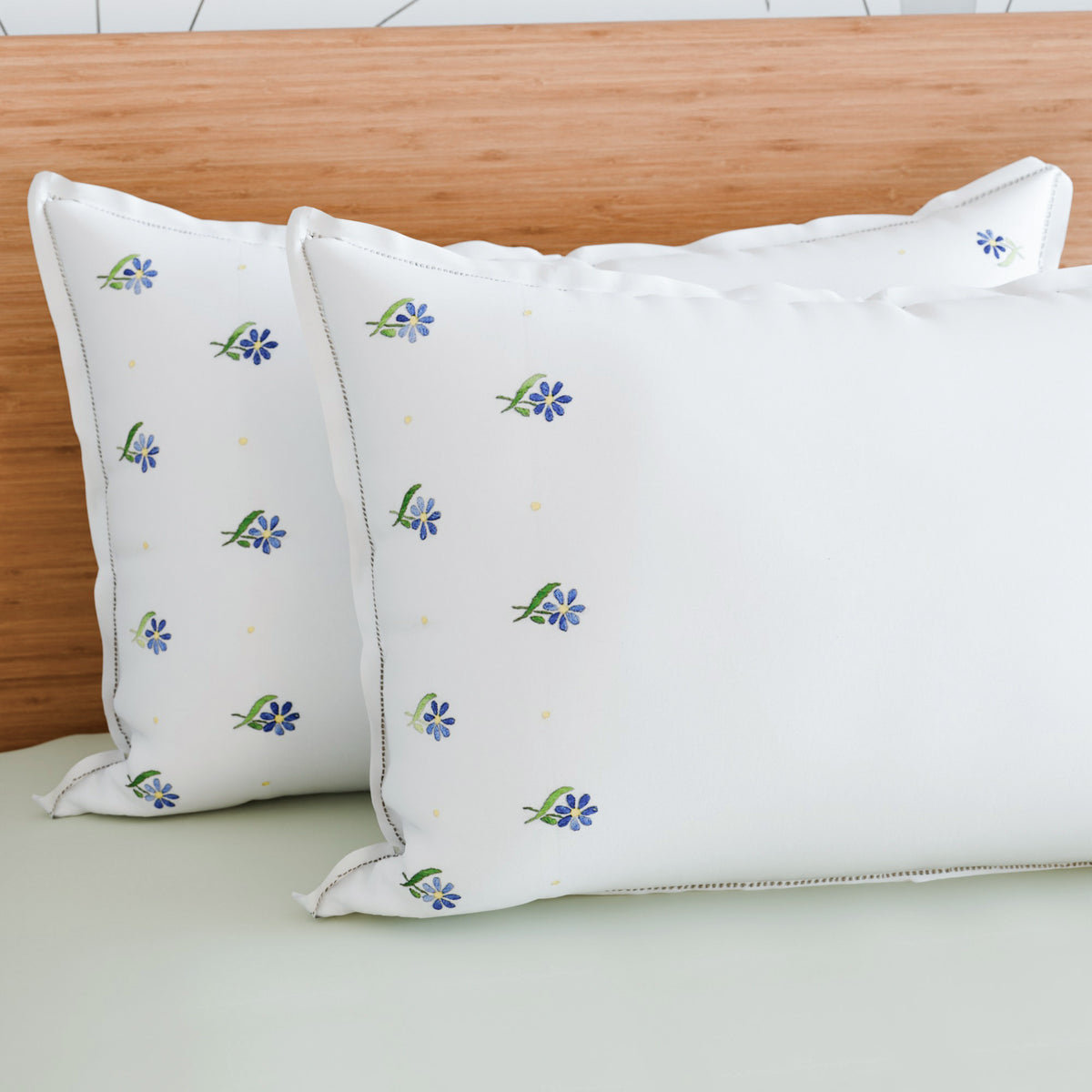 Forget-me-nots embroidered pillow cases styled on a bed adding soft floral elegance to bedroom decor