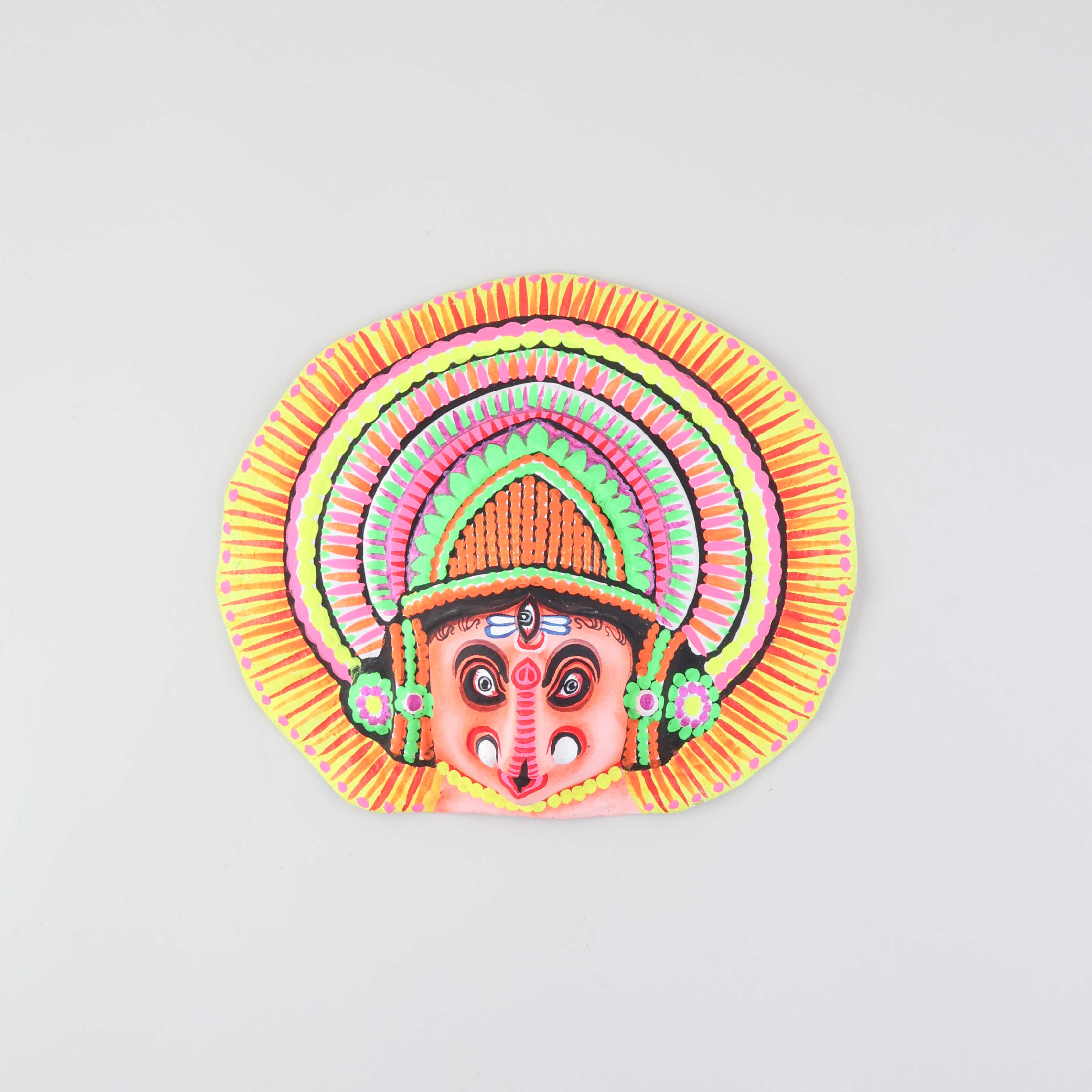 Peach and multi-coloured Ganesha Chhau wall mask handcrafted from clay, cloth, and paper, displayed on a plain background