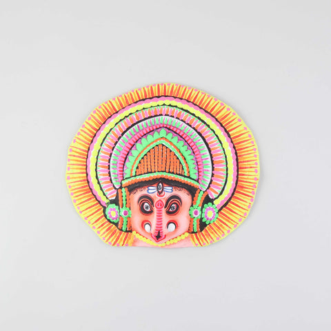 Peach and multi-coloured Ganesha Chhau wall mask handcrafted from clay, cloth, and paper, displayed on a plain background