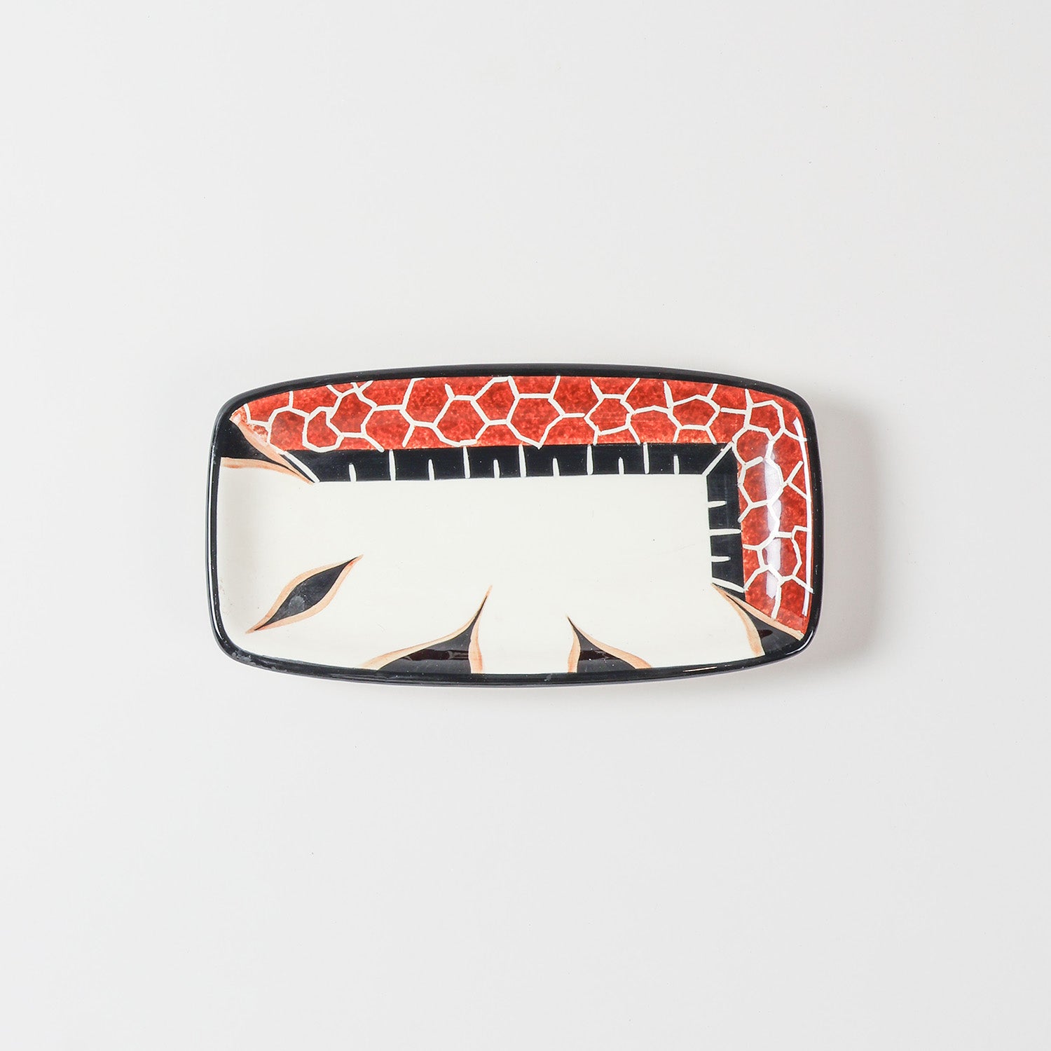 Top view of a handmade ceramic platter featuring a giraffe illustration and decorative African-inspired patterns on a glossy surface