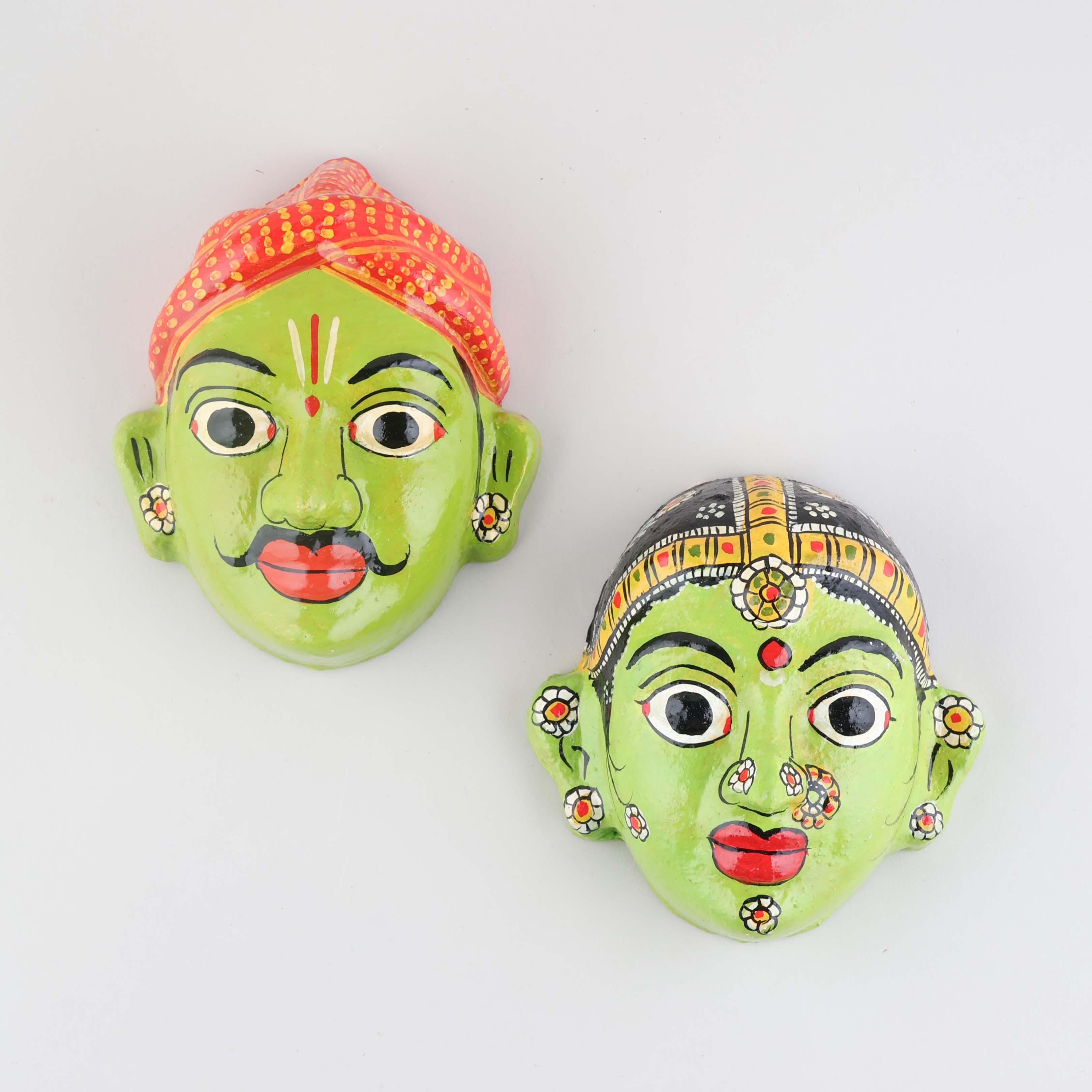 Hand-painted green Cheriyal couple mask set crafted from papier-mache, featuring traditional folk art details on a plain background