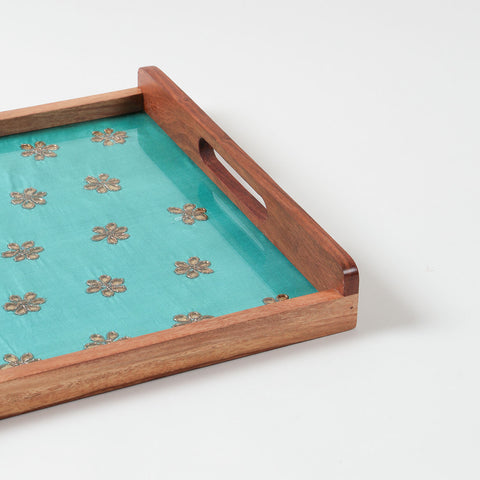 Close-up of green chanderi fabric with golden gota patti floral embroidery used in handcrafted wooden serving tray