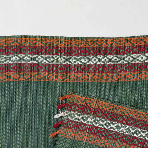 Detailed close-up of a green Madhurkathi placemat showcasing the dense natural fibre weave, geometric pattern, and durable stitched border