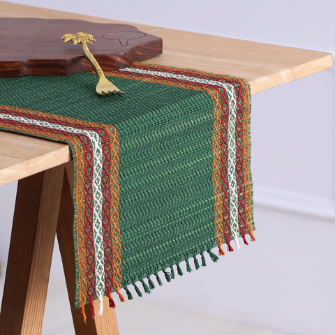 Handmade green Madhurkathi table runner styled on a dining table, highlighting the natural river grass weave, colourful borders, and elegant table setting