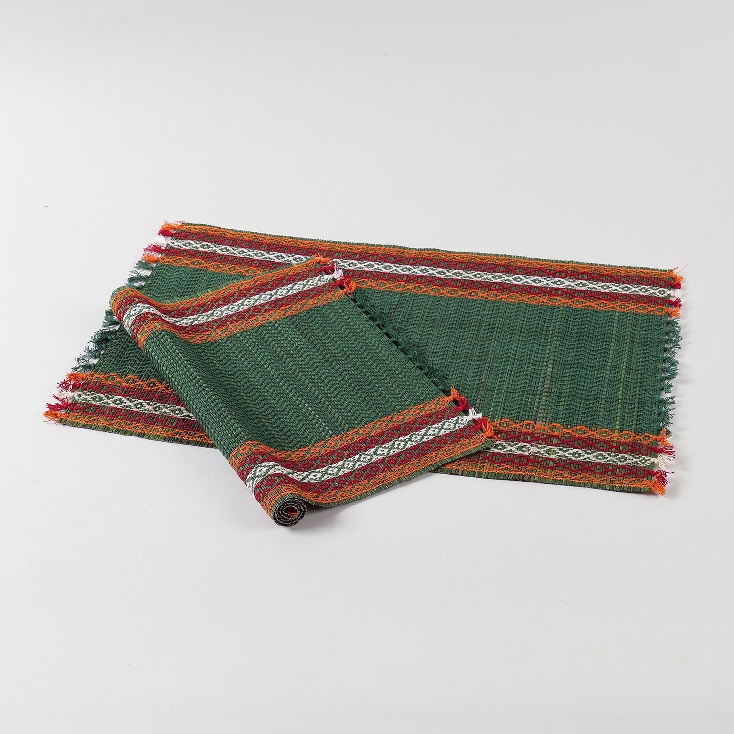  Set of green Madurkathi placemats displayed flat, showcasing handwoven river grass texture and red, white, and orange borders