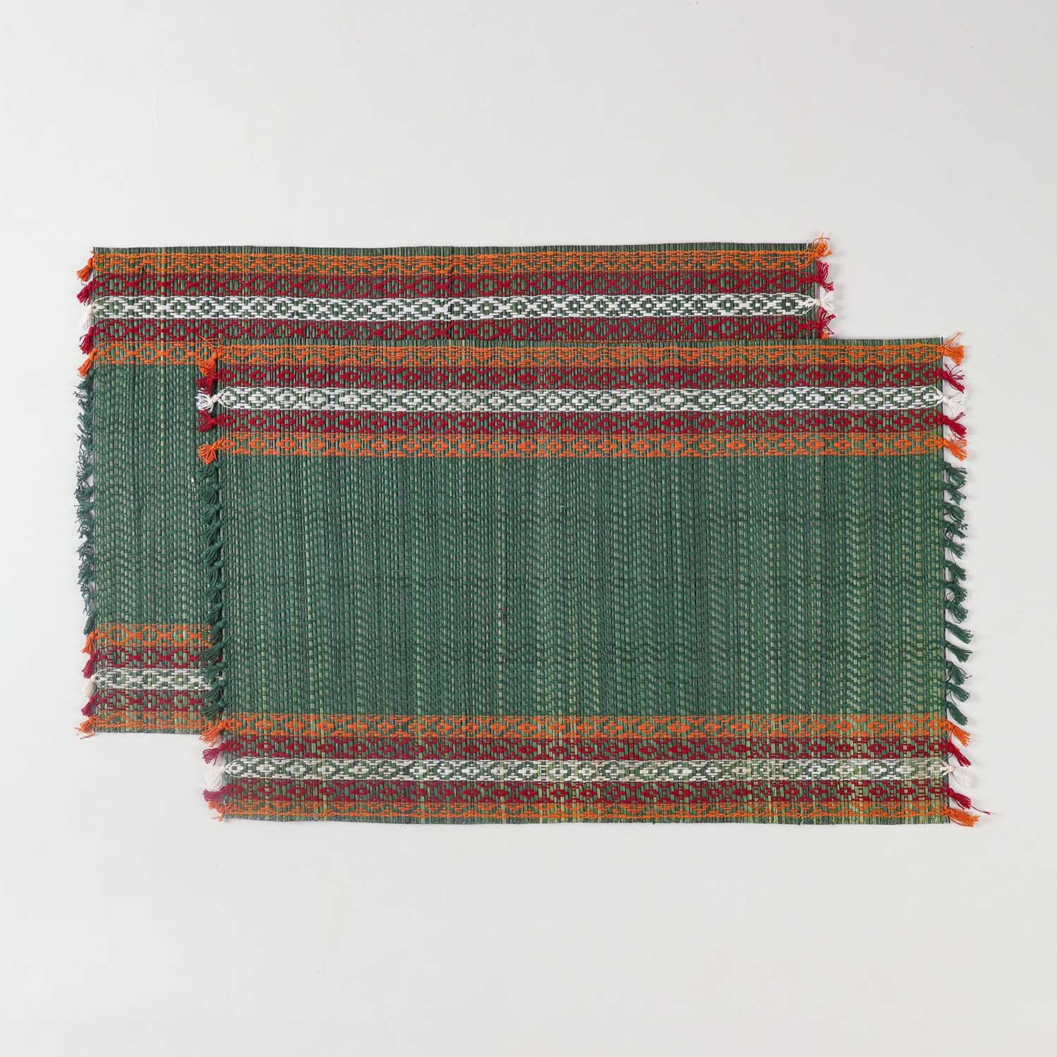 Handwoven green Madurkathi placemat set crafted from natural river grass with red, white, and orange border accents