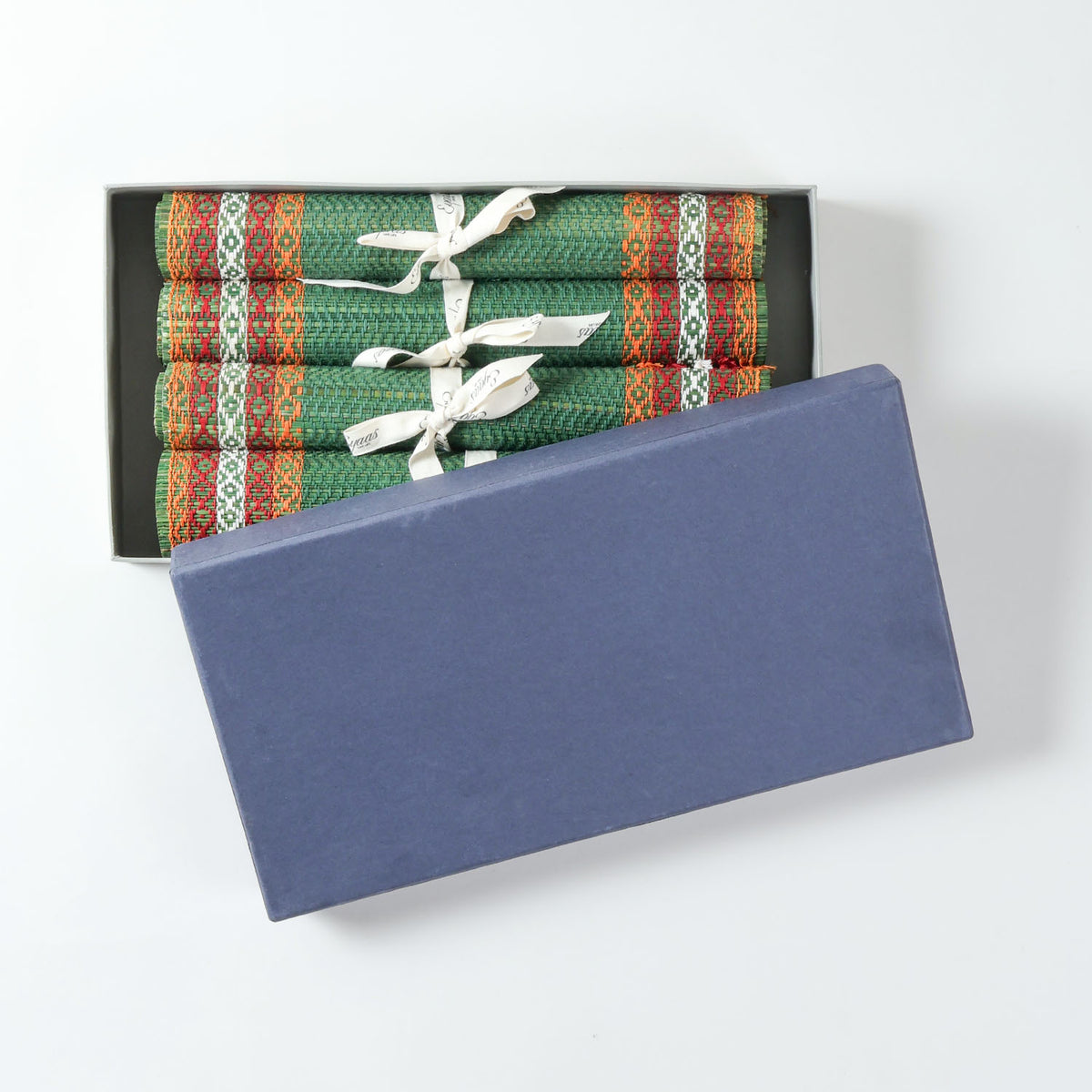 Handmade green Madurkathi table runner and placemat set packed in a gift box, featuring natural fibre weaving and colourful border detailing