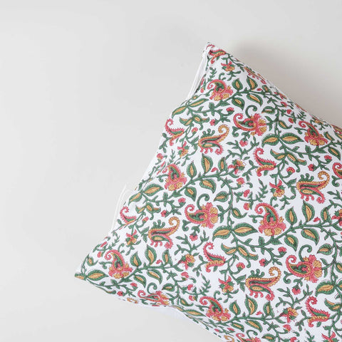 Angled close-up of cotton pillow cover fabric featuring traditional hand block printed paisley jaal motifs in green, pink, and mustard colours