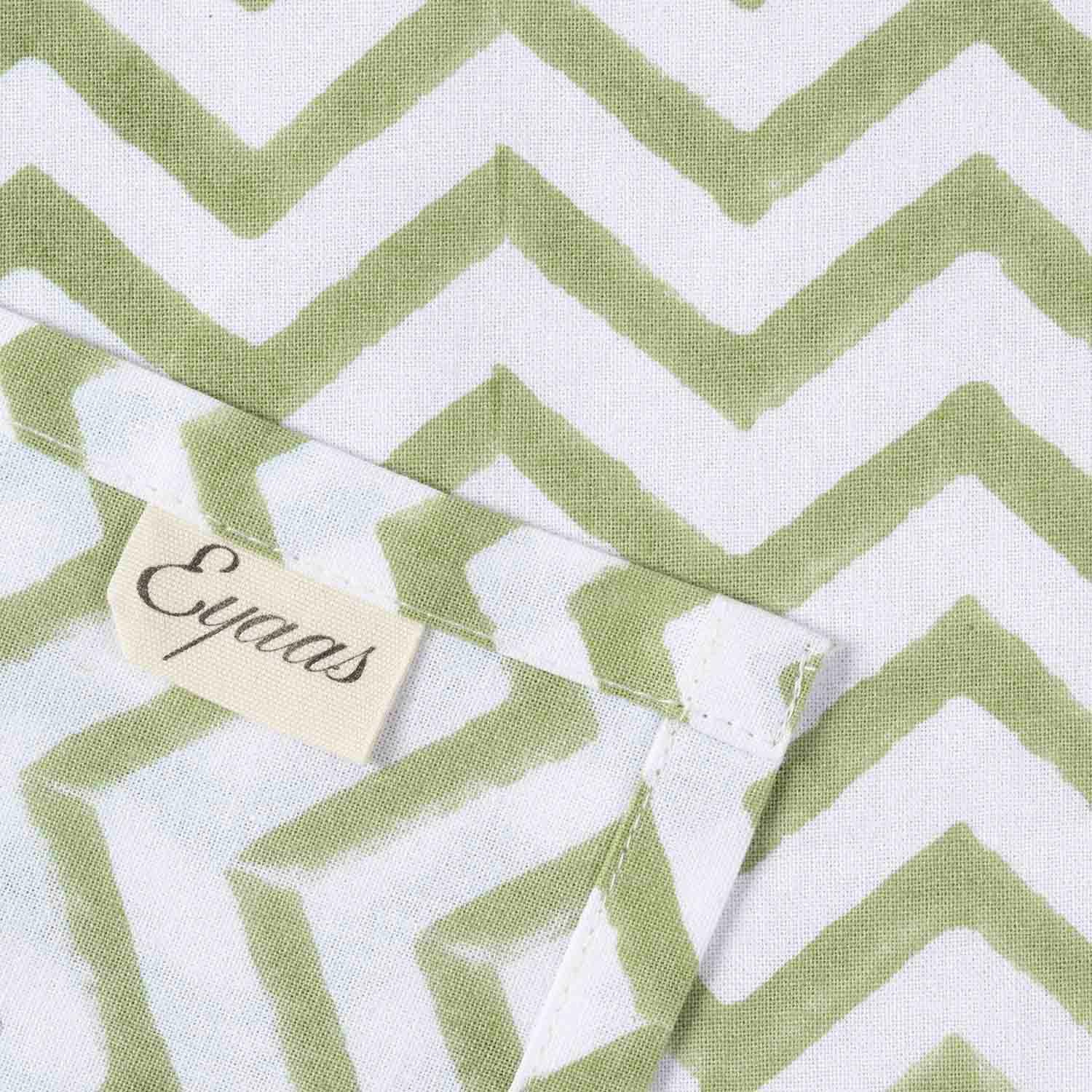 Front and reverse view of green zigzag block printed cotton napkins with Eyaas brand tag detailing