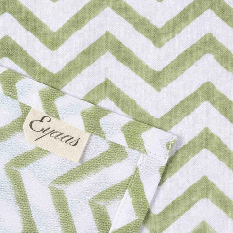 Front and reverse view of green zigzag block printed cotton napkins with Eyaas brand tag detailing