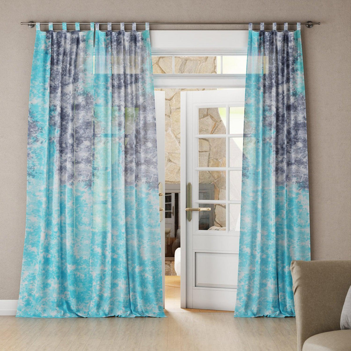 Living room with a grey and blue tie-dye mulmul cotton curtain, and it's a soft, breezy drape.