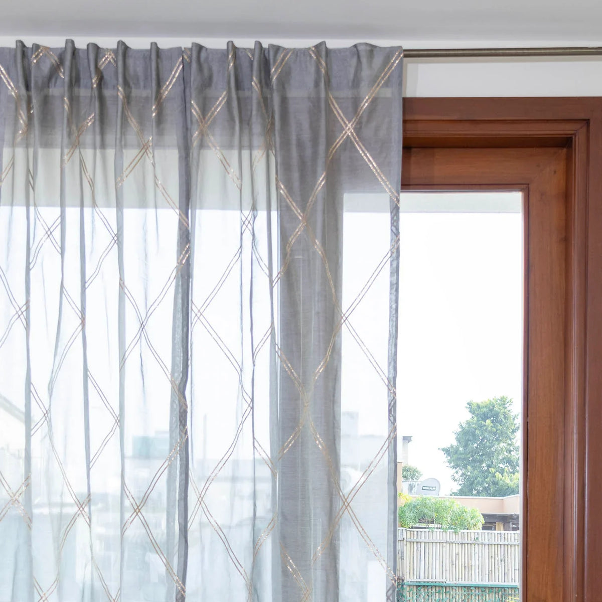 Grey Chanderi sheer curtain styled on a window allowing soft natural light into the room