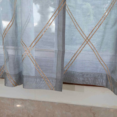 Close-up of the lower section of a grey Chanderi sheer curtain showcasing hand-stitched Gota Patti detailing and elegant drape