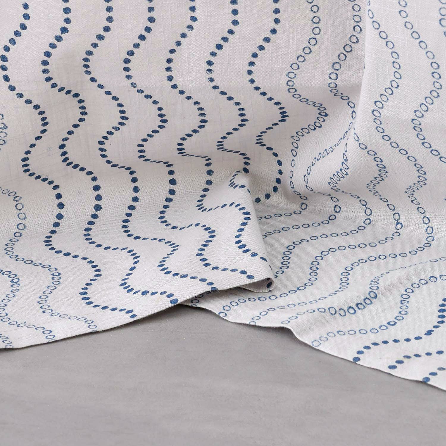 Close-up of the lower portion of grey cotton door curtains with blue wave block print showing the handcrafted pattern and soft cotton slub fabric