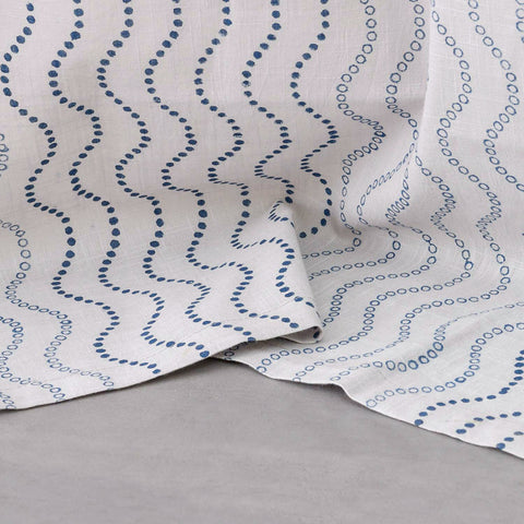 Close-up of the lower portion of grey cotton door curtains with blue wave block print showing the handcrafted pattern and soft cotton slub fabric
