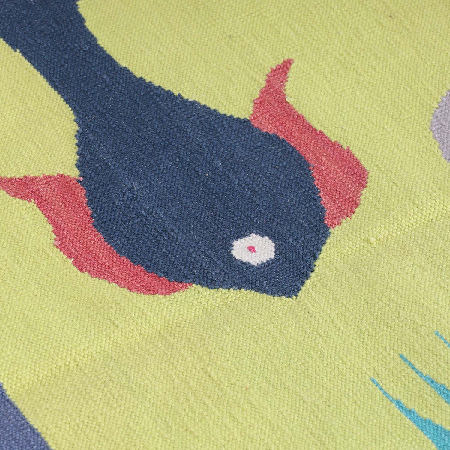 Close-up of handwoven cotton rug highlighting intricate duck and fish motifs and artisan weaving craftsmanship