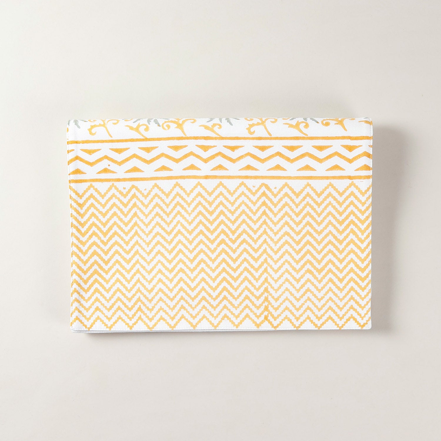 Folded cotton table runner featuring grey and yellow floral motifs with handcrafted block printing