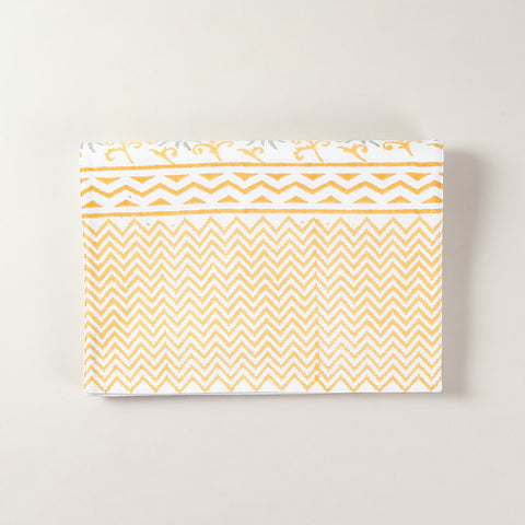 Folded cotton table runner featuring grey and yellow floral motifs with handcrafted block printing