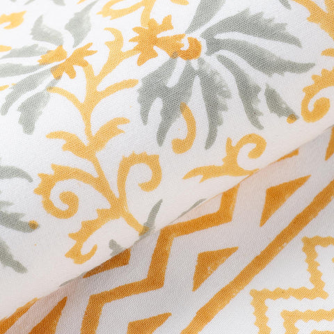Close-up of grey floral pattern with orange and yellow border on cotton table runner