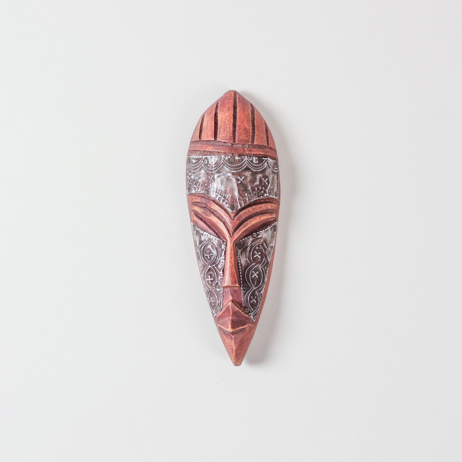 Hand carved African wooden mask with metal accents, almond-shaped eyes, carved facial details, and traditional tribal design on a plain background
