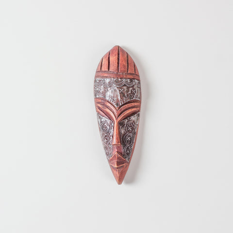 Hand carved African wooden mask with metal accents, almond-shaped eyes, carved facial details, and traditional tribal design on a plain background