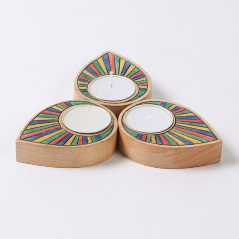 Set of three hand carved wooden t-light holders featuring rainbow colours and raindrop inspired shapes
