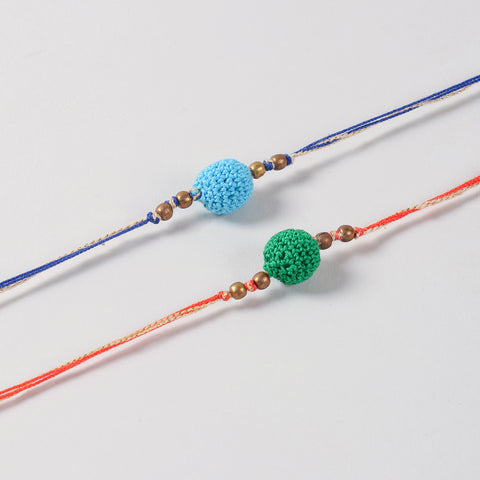 Close-up of the Handmade Cotton Yarn Crochet Bead Rakhi highlighting the hand-crocheted green and blue beads with antique bronze bead accents