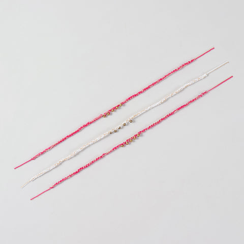 Full-length view of the Handmade Crochet Brass Bead Rakhi showing the complete braided cotton thread and handcrafted brass bead design.
