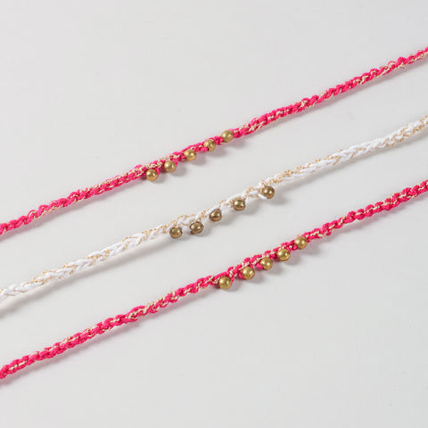 Close-up of the Handmade Crochet Brass Bead Thread Rakhi highlighting the hand-crocheted cotton threads, brass beads, and gold thread detailing