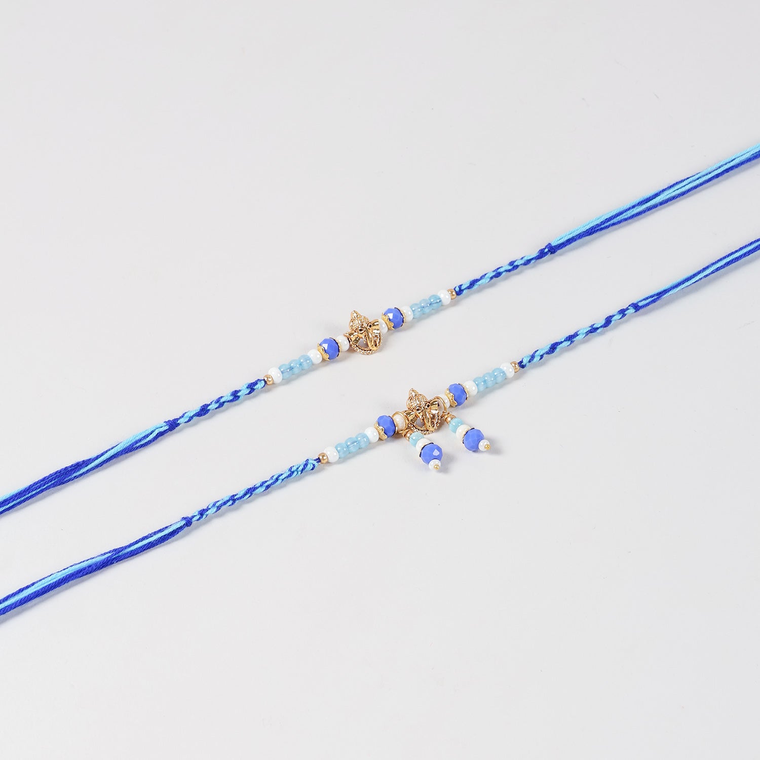 Close-up of the Handmade Ganesh Rakhi & Lumba Set featuring the Ganesh charm, blue beads, and handcrafted detailing.