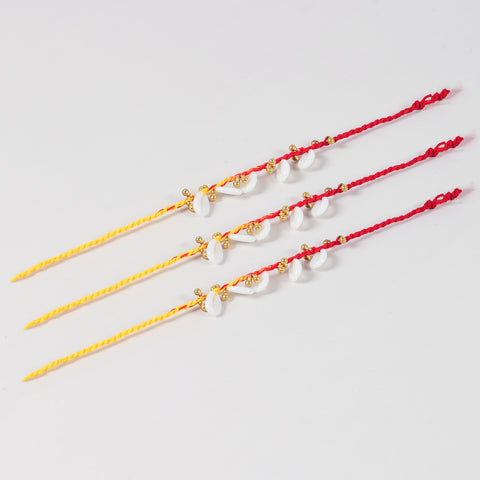 Full-length view of the handmade ghungroo and sea shell Rakhi Set of 3 showing handcrafted sea shells, ghungroos, and festive thread.