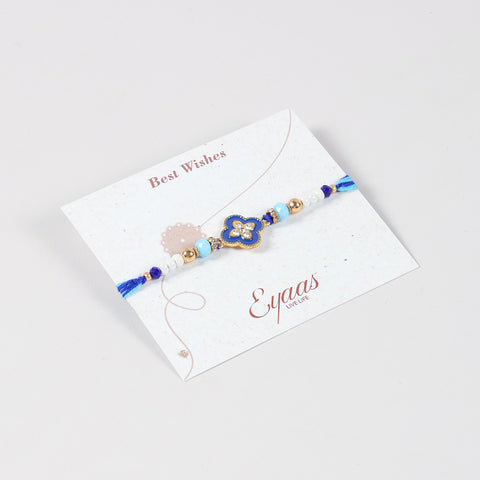 Angled view of the Handmade Metal Floral Rakhi attached to a Best Wishes greeting card for Raksha Bandhan gifting.