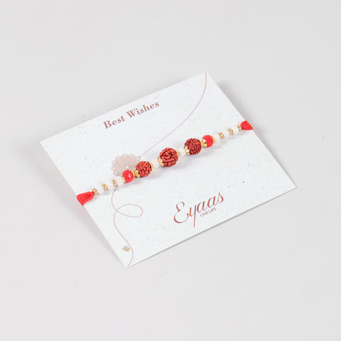 Angled view of the Handmade Rudraksha Rakhi attached to a Best Wishes greeting card for Raksha Bandhan gifting.