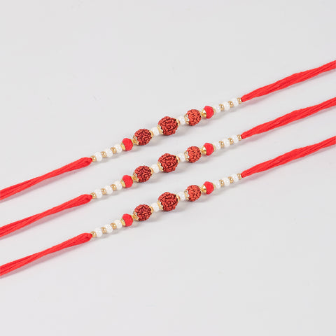 Close-up of the Handmade Rudraksha Rakhi featuring natural Rudraksha beads, white pearls, red beads, and gold-toned decorative accents.