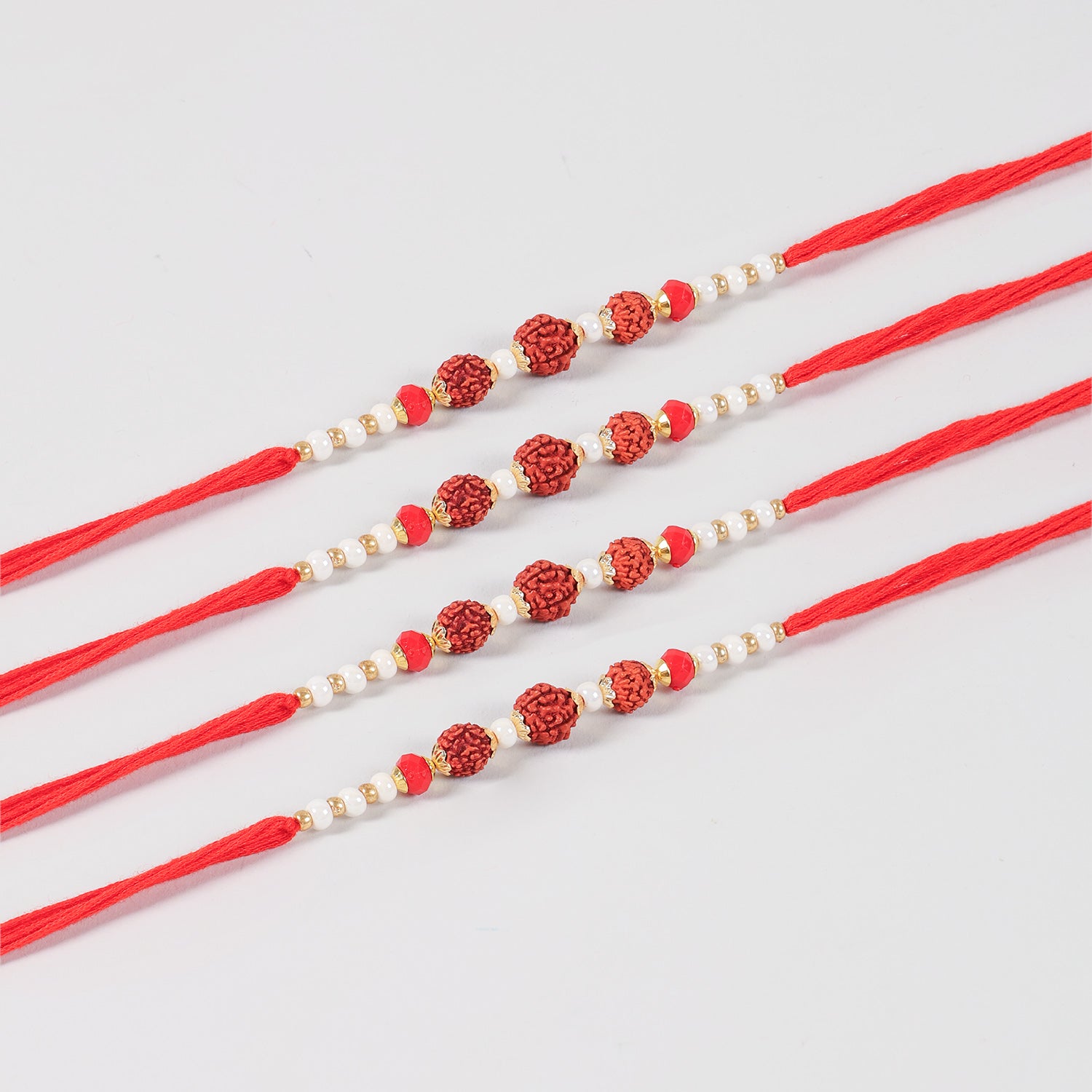 Close-up of the Handmade Rudraksha Rakhi featuring natural Rudraksha beads, white pearls, red beads, and gold-toned decorative accents.